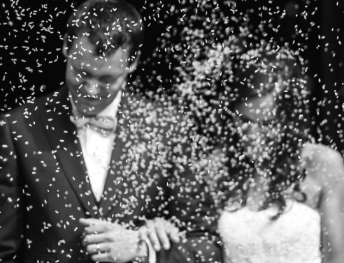 Ασπρόμαυρη φωτογραφία με ζευγάρι που παντρεύται και του πετάνε ρύζι