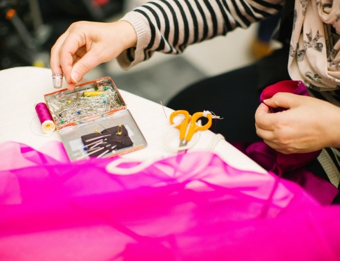 Γυναίκα πιάνει καρφίτσες από το τραπέζι