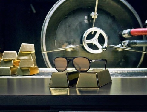 Γυαλιά ηλίου Persol ακουμπισμένα πάνω σε πλάκες χρυσού