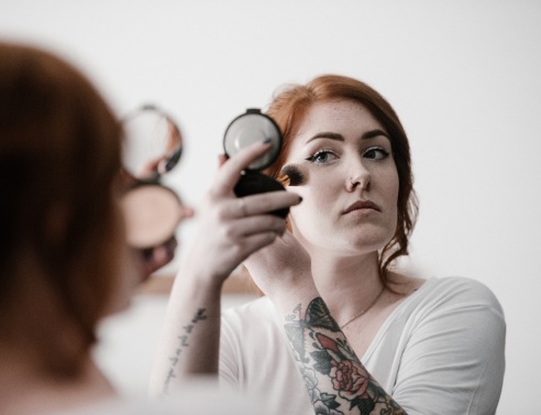 Κοπέλα που βάφεται σε καθρεφτάκι