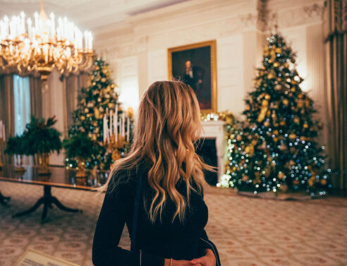 Γυναικα με κεφάλι γυρισμένο δεξιά και φόντο σαλόνι στολισμένο με χριστουγεννιάτικο και χριστουγεννιάτικο δέντρο