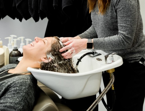 Κομμώτρια λούζει κοπέλα σε λουτήρα κομμωτηρίου