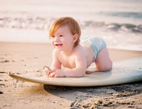 Μωρό σε σανίδα του σερφ στην παραλία