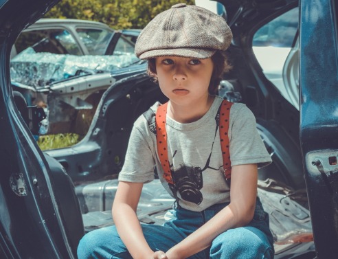 Παιδί με μπερέ που κάθεται σε αυτοκίνητο