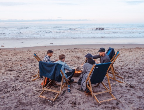 Τέσσερις φίλοι κάθονται σε καρέκλες στην παραλία
