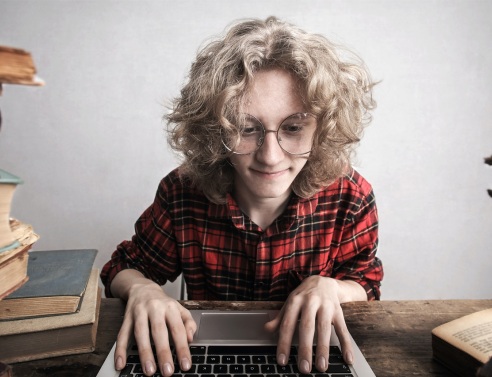 Γυναίκα με γυαλιά πληκτρολογεί σε laptop