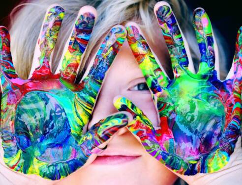 Μικρό παιδί που έχει λερώσει τα χέρια του με χρώμα