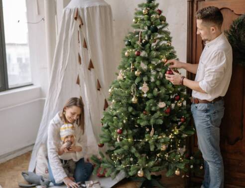 Οικογένεια στολίζει το χριστουγεννιάτικο δέντρο