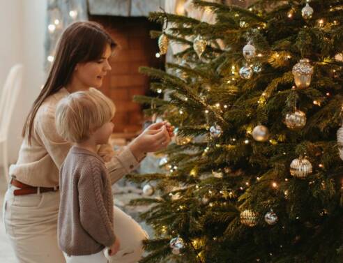 Μαμά και παιδί στολίζουν το χριστουγεννιάτικο δέντρο