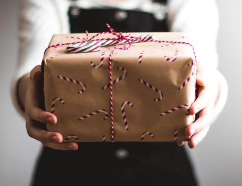 Μια κοπέλα κρατάει ένα δώρο.