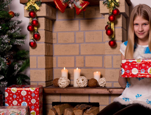 Ένα κορίτσι κρατάει στα χέρια του το χριστουγεννιάτικο δώρο του