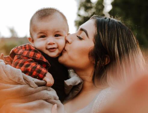 Μια μητέρα κρατάει αγκαλιά το μωρό της