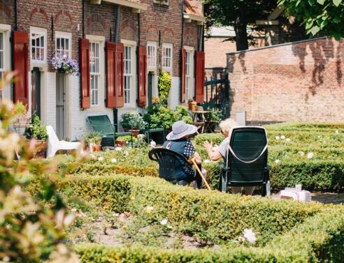 Δύο ηλικιωμένες κυρίες κάθονται σε καρέκλες στον κήπο