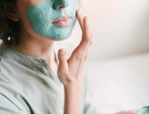 Κοπέλα απλώνει μάσκα ομορφιάς στο πρόσωπό της