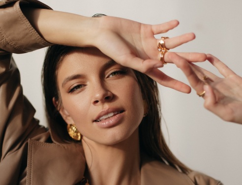 Μελαχρινή κοπέλα κοιτάει την κάμερα και χαμογελάει