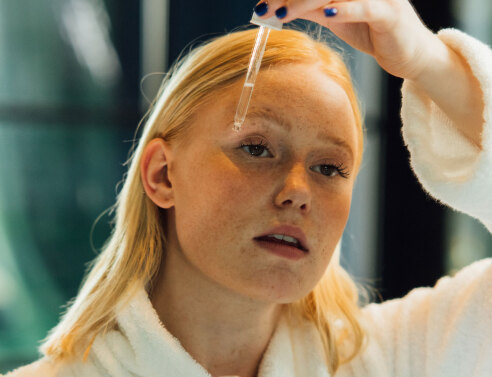 Κοπέλα που βάζει σέρουμ στο πρόσωπό της