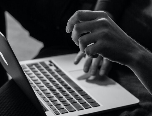 Άντρας με λάπτοπ στα πόδια του