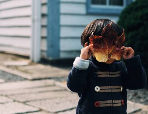 Μικρό παιδί που έχει βάλει ένα φύλλο μπροστά στο πρόσωπό του