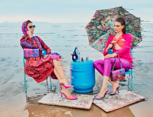 Γυναίκες με χρωματιστά ρούχα καθισμένες σε καρέκλες σε παραλία