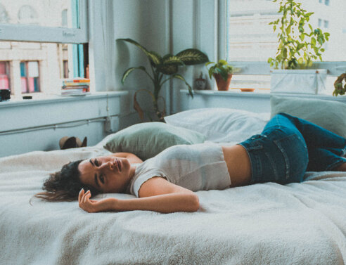 Γυναικα ξαπλωμένη με τα ρούχα σε κρεβάτι