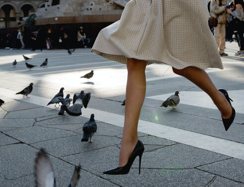 Γυναίκα περπατάει με τακούνια σε πλατεία