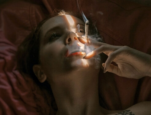 Γυναίκα ξαπλωμένη καπνίζει