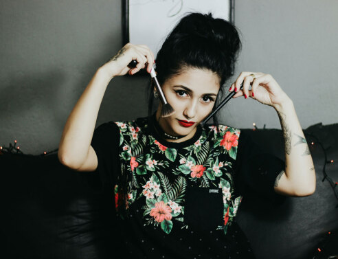 Γυναίκα κρατάει πινέλα δίπλα στα μάγουλά της