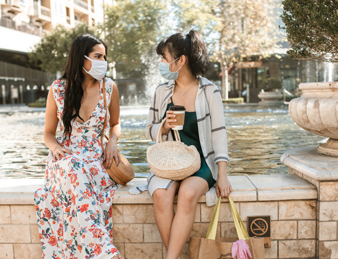 Δύο φίλες συζητούν φορώντας μάσκα για τον κορωνοιο