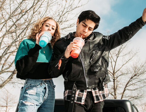 Έφηβοι, κορίτσι και αγόρι πίνουν αναψυκτικό