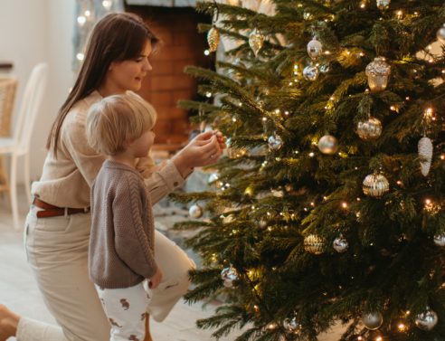 Μαμά και παιδί στολίζουν χριστουγεννιάτικο δέντρο