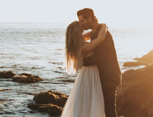 Ζευγάρι φιλιέται με φόντο το ηλιοβασίλεμα