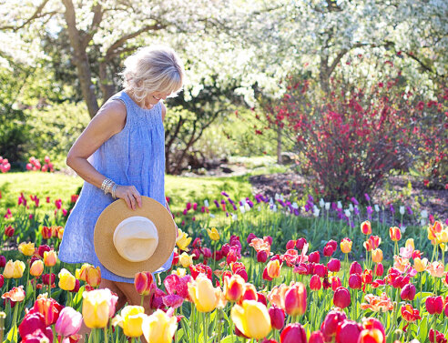Γυναίκα με άσπρα μαλλιά ανάμεσα σε τουλίπες