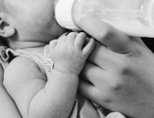 Μωρό που πίνει γάλα από μπιμπερό