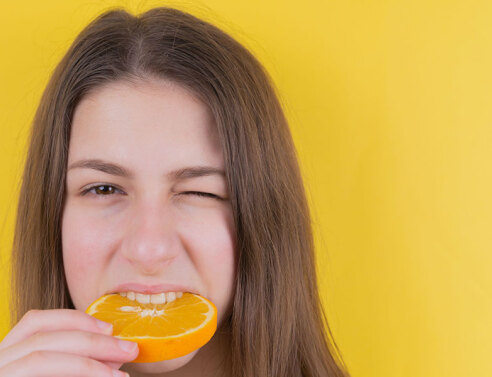 Κοπέλα δαγκώνει πορτοκάλι