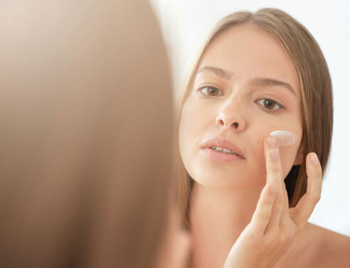 Γυναίκα βάζει κρέμα στο πρόσωπο