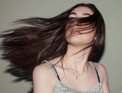 κοπέλα με λαμπερά κάστανα μαλλιά 