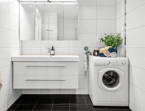 Μπάνιο με λευκά πλακάκια και λευκό πλυντήριο ρούχων