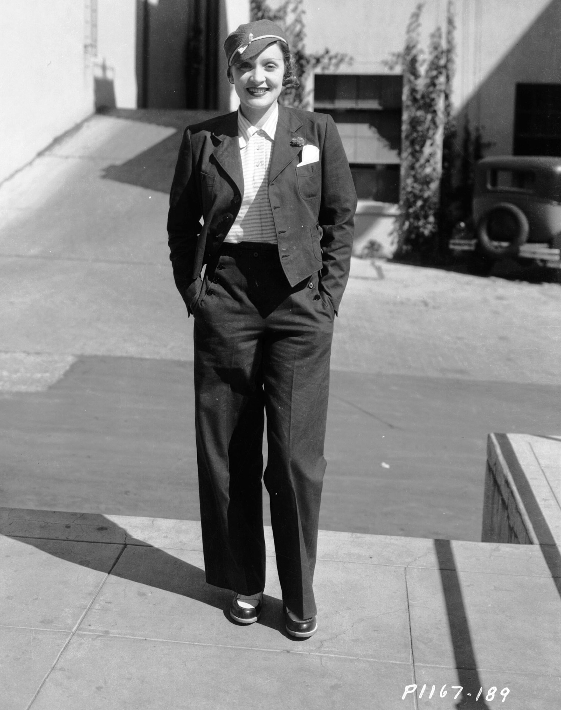 Μαρλέν Ντίτριχ, περίπου το 1933. Ντυμένη με παντελόνι, σακάκι και καπέλο χαμογελάει στον ήλιο με τα χέρια στις τσέπες
