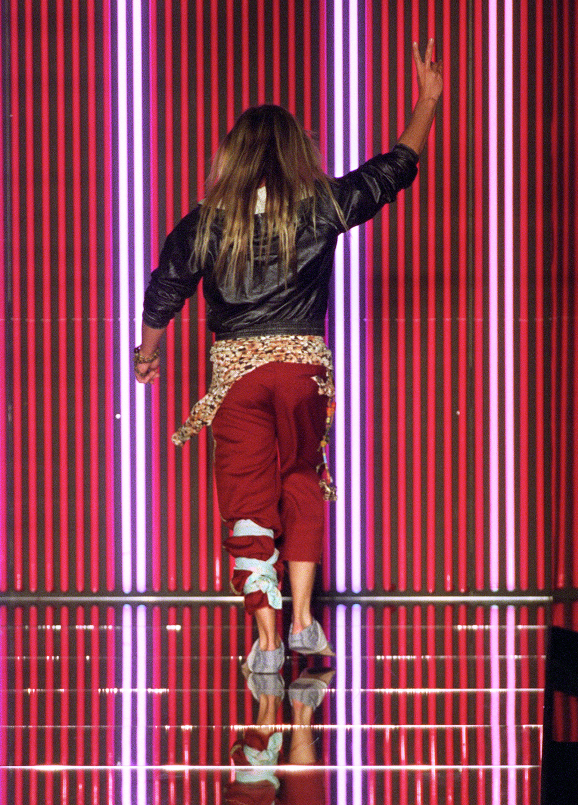 Ο John Galliano κάνει το σήμα της ειρήνης στο κλείσιμο του σόου για τη συλλογή Άνοιξη-Καλοκαίρι 2002 © AFP PHOTO PIERRE VERDY (FILM)