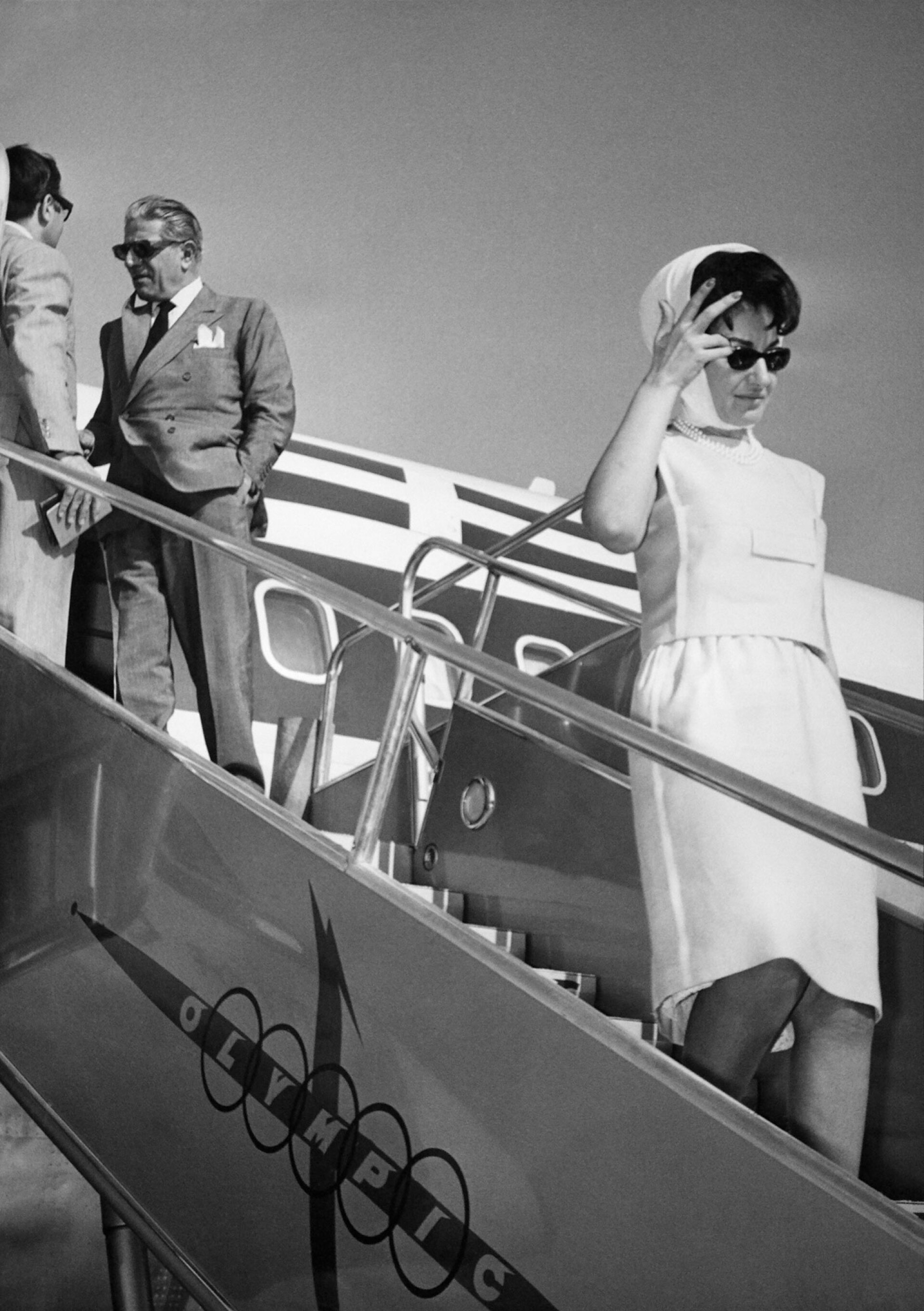 Η Μαρία Κάλλας με φουλάρι Gucci κατεβαίνοντας τις σκάλες του αεροπλάνου. Πίσω της διακρίνεται ο Αριστοτέλης Ωνάσης © KEYSTONE-FRANCE/Gamma-Rapho via Getty Images