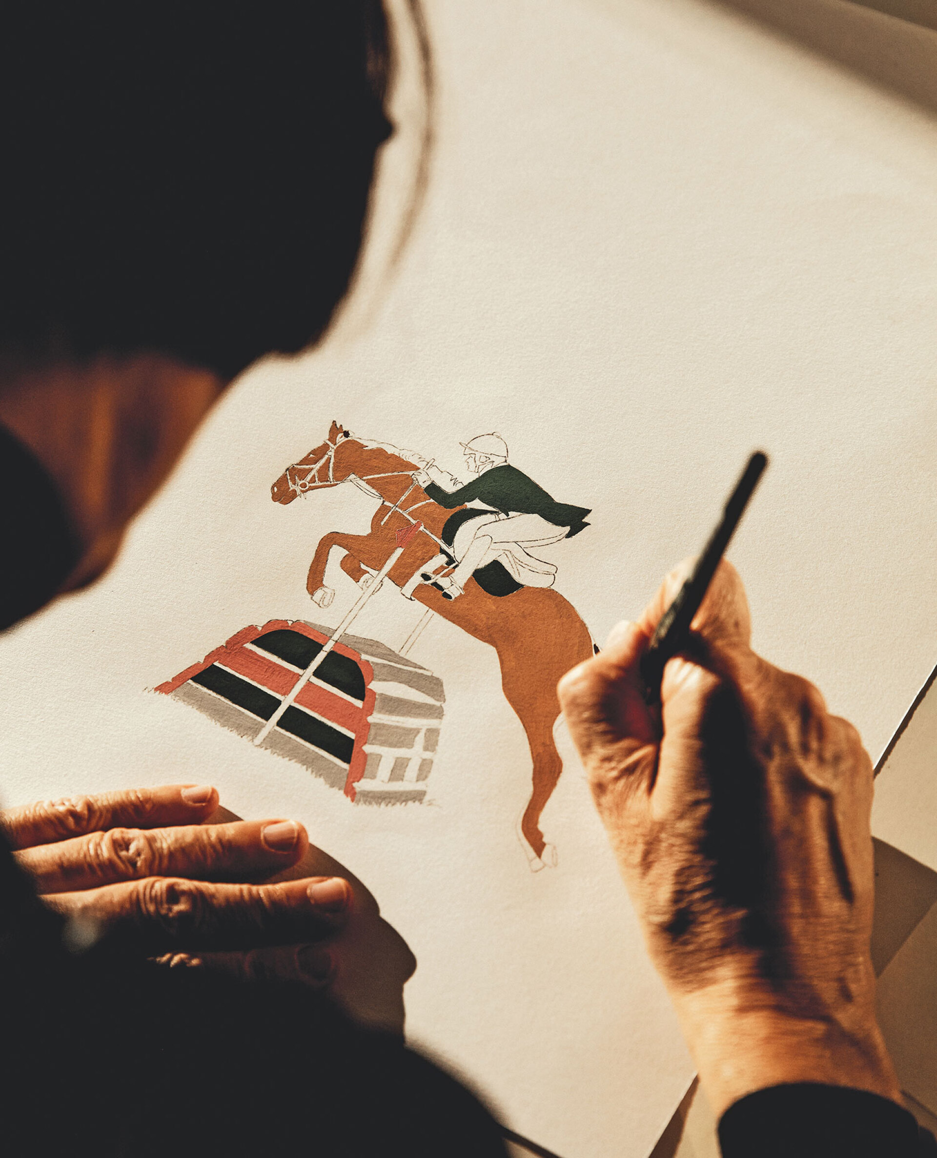 O καλλιτέχνης ζωγραφίζει τον ιππέα για μεταξωτό μαντίλι στο ατελιέ του Οίκου στο Μιλάνο © Oliver Pilcher