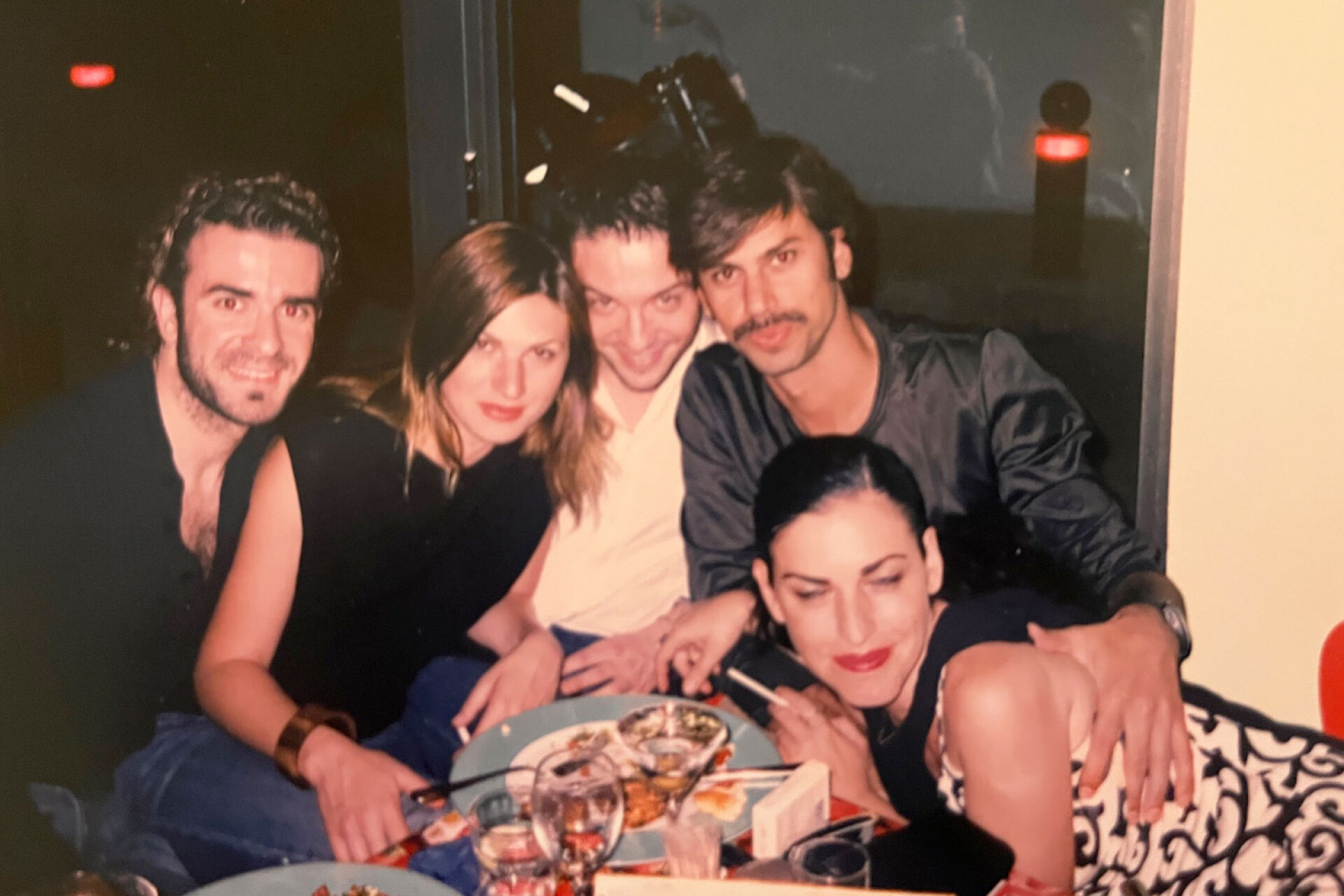 H Ελένη Ψυχούλη, ιδιοκτήτρια του μπαρ-εστιατορίου σε πρώτο πλάνο, ο fashion editor Μιχάλης Πάντος πίσω της και δίπλα του ο casting director Μάκης Γαζής | Βee, 90s 