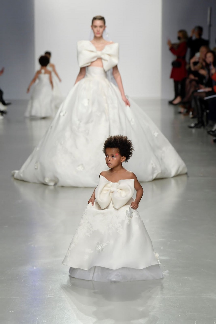 Μικρό μαύρο κοριτσάκι με λευκό φόρεμα στην επίδειξη μόδας της Σίλιας Κριθαριώτη για τη σεζόν SS22