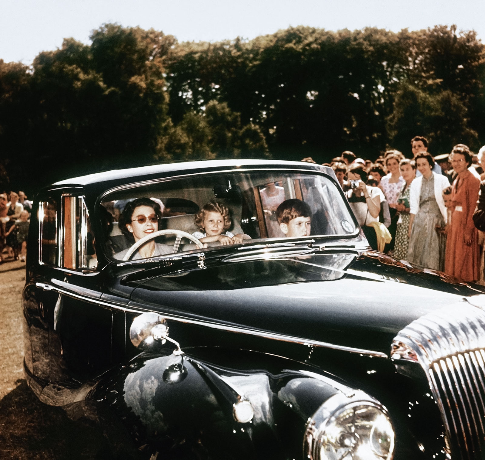  Bettmann/Corbis // Caption: Οδηγώντας στο Windsor με τα δυο της παιδιά στο πίσω κάθισμα της πολυτελούς της Daimler, 1957 // Photo: ανώνυμος 