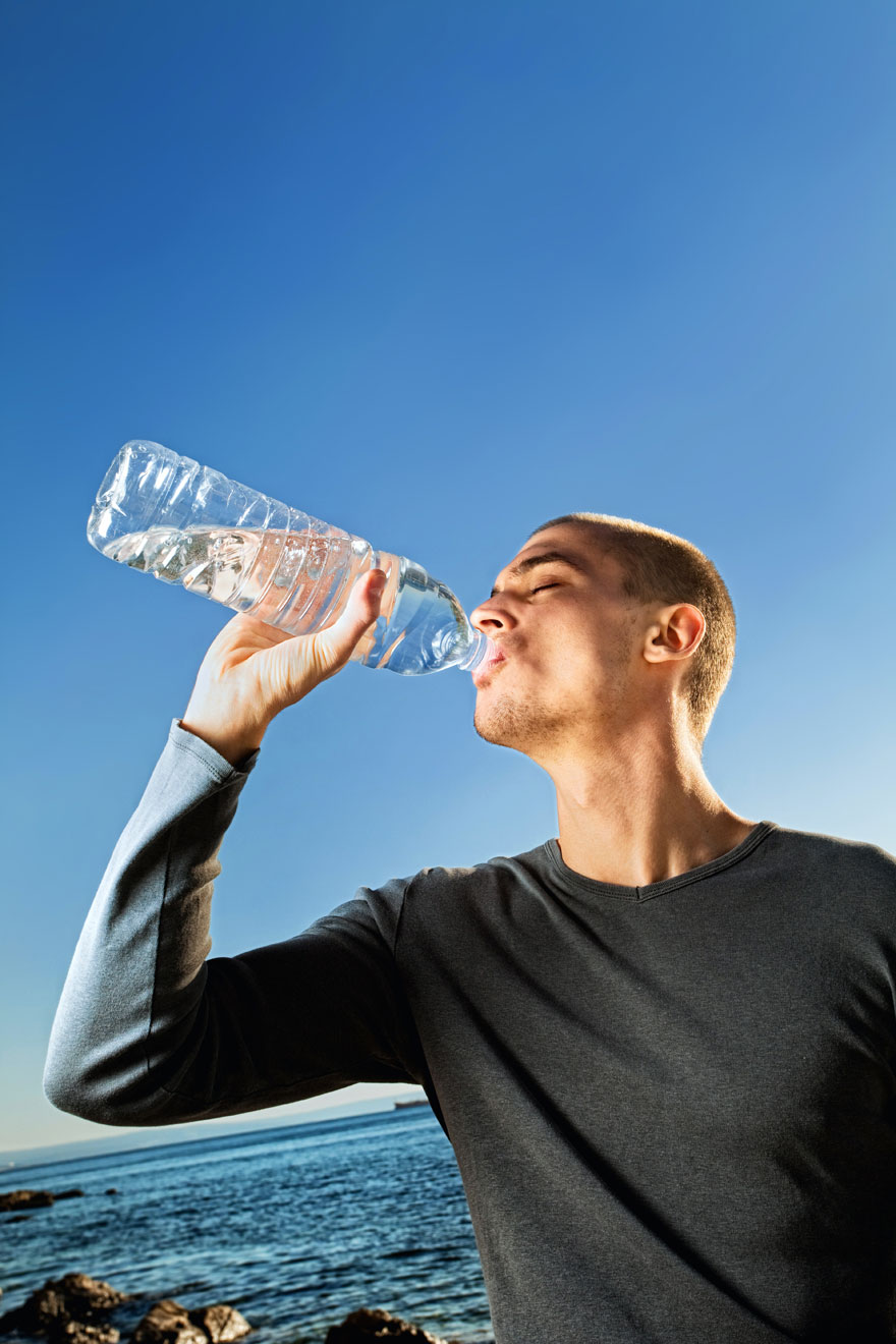Άντρας πίνει νερό από πλαστικό μπουκάλι