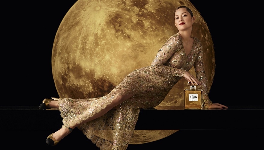 Η Marion Cotillard με χρυσό κεντημένο φόρεμα ποζάρει δίπλα στο άρωμα Chanel Νο5