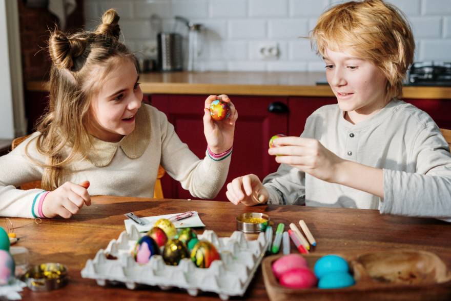 Παιδιά στην κουζίνα βάφουν πασχαλινά αυγά